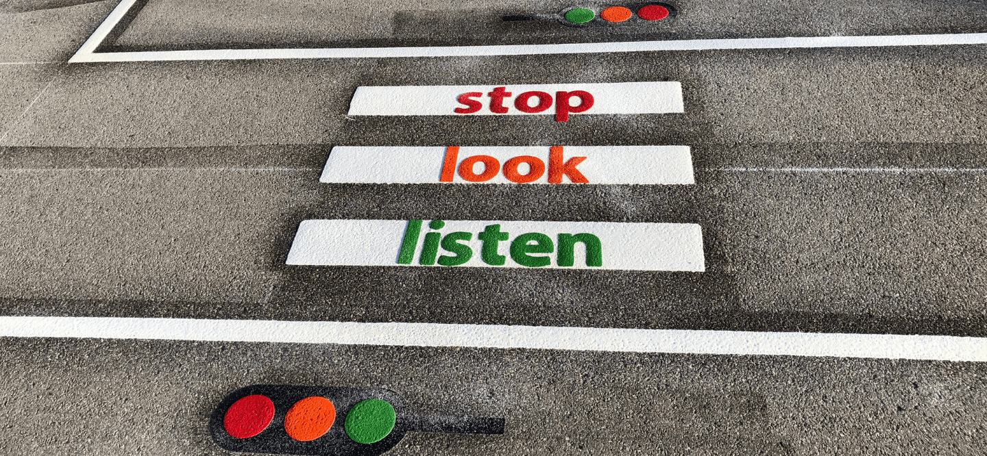 Stop, look, listen road safety marking in red, amber and green, with traffic light symbols at each end of the crossing