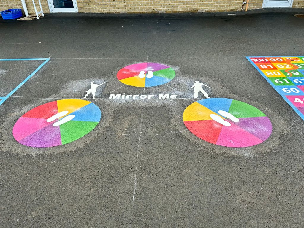 Mirror Me game with three rainbow circles, white footprints and posing figures beside a 1 to 100 number grid