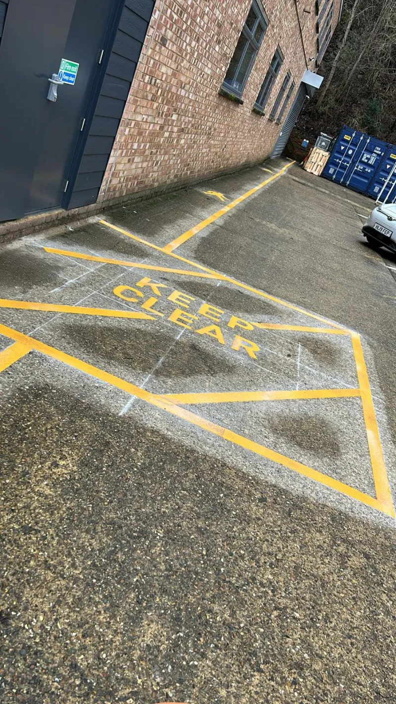 Keep-clear marking with yellow cross-hatching outside a commercial unit
