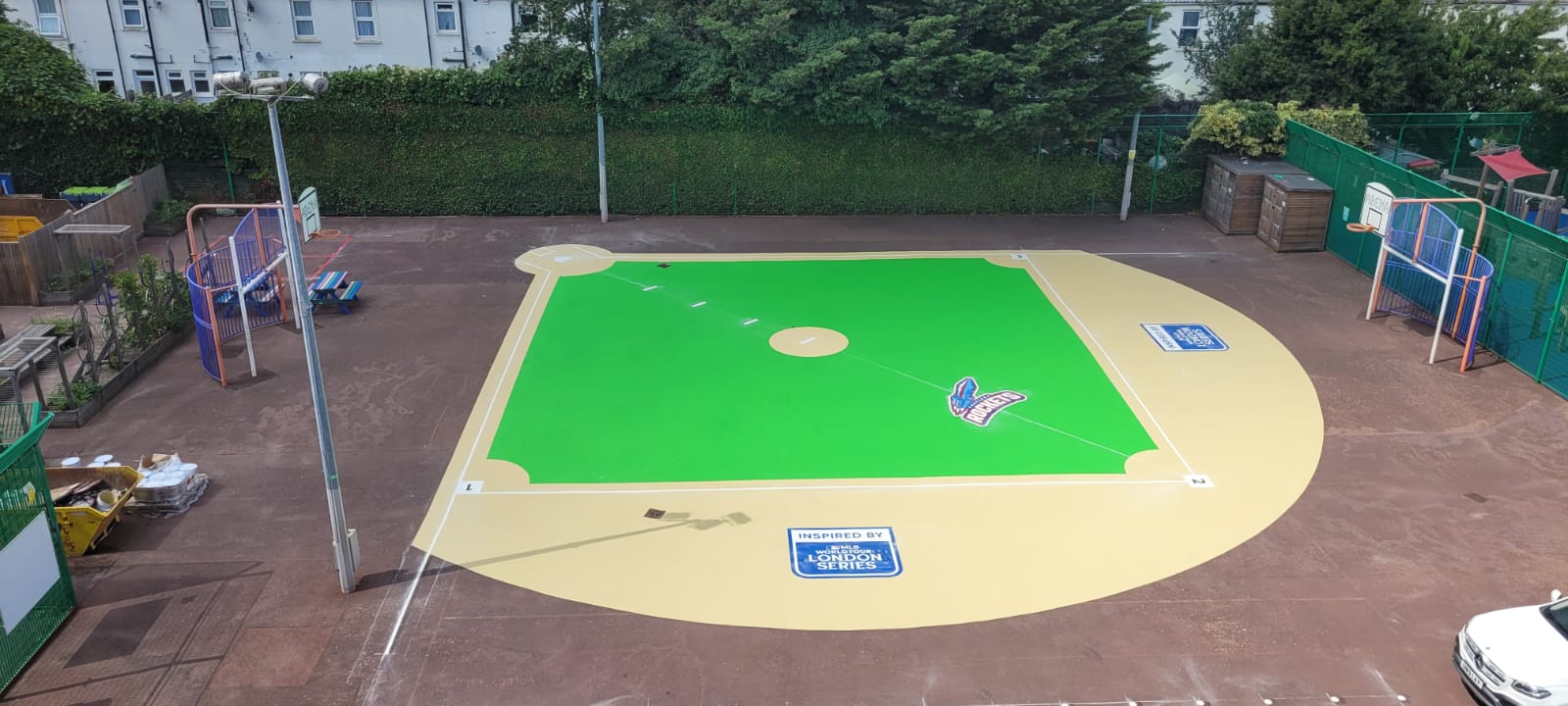 Ranelagh Rockets baseball field marked in green and sand across a red tarmac school playground, seen from above