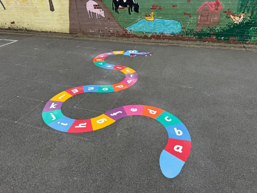 A to Z Snake winding below a painted farm animal mural on a brick wall