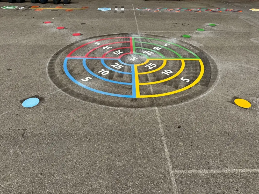 4 Way Target in red, green, blue and yellow quarters marked on grey playground tarmac