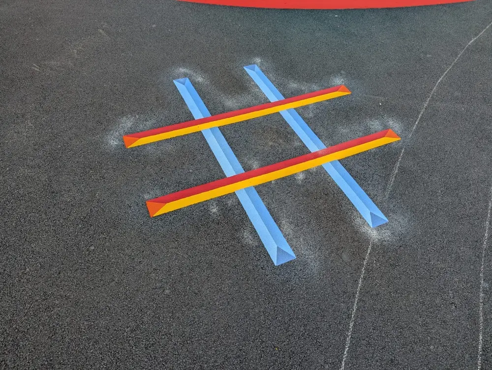 Close-up of a Noughts and Crosses grid with raised 3D bars beside a red circle marking