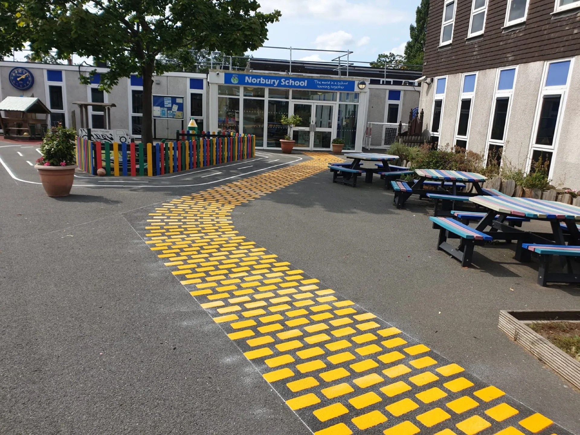 A school playground marked out with colourful thermoplastic games and designs