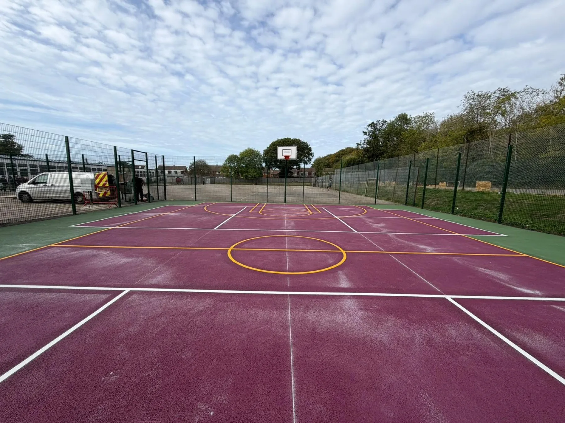 Coloured surface with a basketball key and centre circle marked in yellow