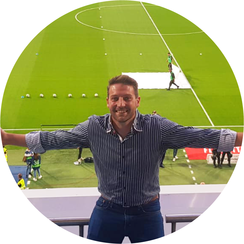 Michael Jarvie, Operations Director at Uniplay, arms spread wide in a stadium stand overlooking a football pitch