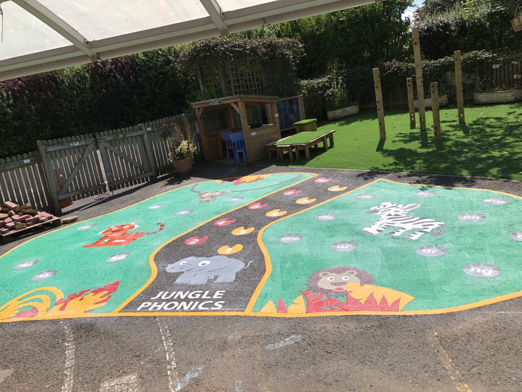 Bright themed mural and wall art beside a school playground